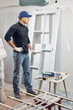 © astrosystem - Young adult man painting on a DIY budget renovation of his new home apartment.