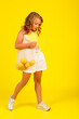 © Nabokov Alex - Teenage girl with an eco bag with lemons in the studio on a yellow background. Bright emotions, fresh trend in pop style