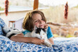 © Mint Images - Young boy lying on outdoor bed stroking a pet cat