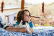 © Mint Images - Young boy lying on outdoor bed stroking a pet cat