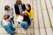 © Iryna - View from above of multi-ethnic group of five college students reading concepts, talking about homework, meeting together in university campus. Education and friendship concept.