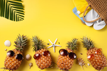 Wall Mural - Summer fruit background design concept. Beach with shells, pineapple and palm leaves on yellow background.