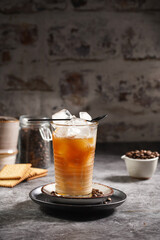 Wall Mural - a black tea spoon on a glass with ice cubes and coffee