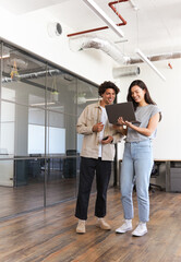 Young couple renting work space for start up business having informal meeting in open plan office