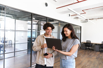 Young couple renting work space for start up business having informal meeting in open plan office