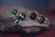 Close-up Of Multi Colored Glass  Marbles On Wood.