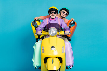 Poster - Photo of grey haired married couple retired pensioner wear helmet sunglass hold bags biker isolated on blue color background