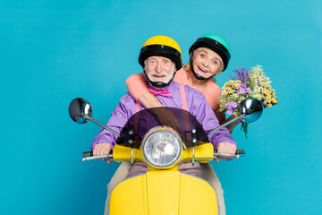 Poster - Photo of retired pensioner grey haired husband wife couple hold flowers ride bike isolated on blue color background