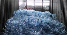 A Lot Of Plastic Blue Bottles With Caps Are In The Storage With A Window In The Background. Storage, Reuse And Processing. Environmental Protection Concept.