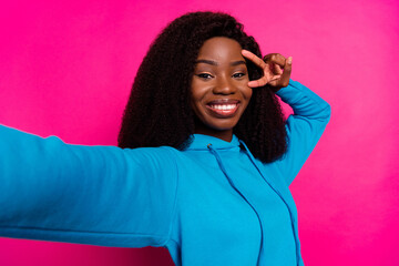 Sticker - Photo portrait of woman in blue clothes showing peace v-sign taking selfie smiling isolated on bright pink color background