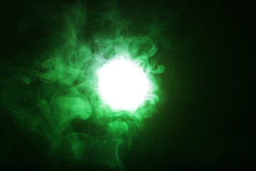 Poster - Artificial magic smoke in green light on black background