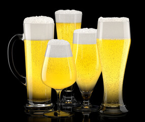 Wall Mural - Set of fresh stout beer glasses with bubble froth isolated on black background.