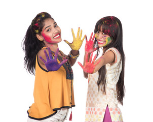 Happy young girls having fun with colorful powder at Holi festival of colors