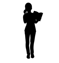 Silhouette of a teenage girl standing with an open book in her hands