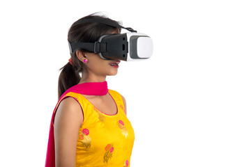 Wall Mural - Indian traditional young girl holding and showing VR device, vr box, goggles, 3D Virtual Reality Glasses headset, Girl with Modern imaging Future technology on white background.