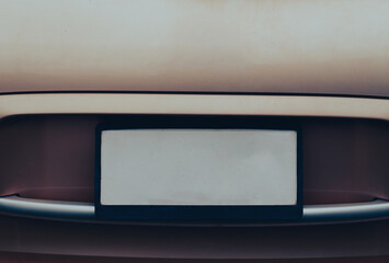 Empty License plate on the back of a beige car