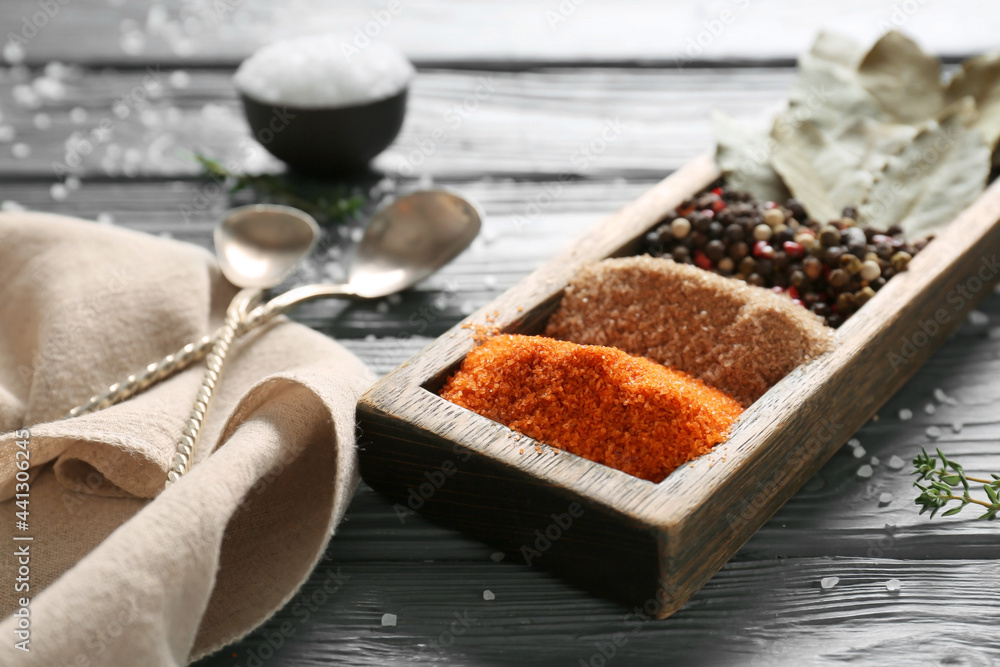 Composition with different salt and spices on dark wooden background, closeup