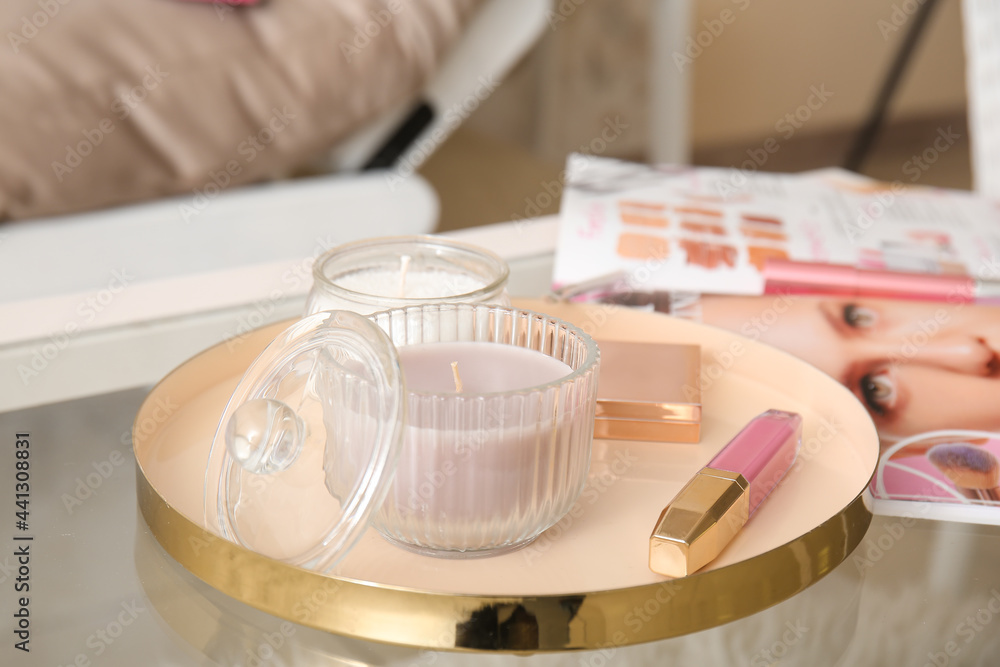 Tray with candles and cosmetics on table