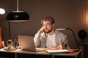 Sticker - Young man studying online at home in evening