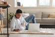 © Pixel-Shot - Young African-American guy studying online at home