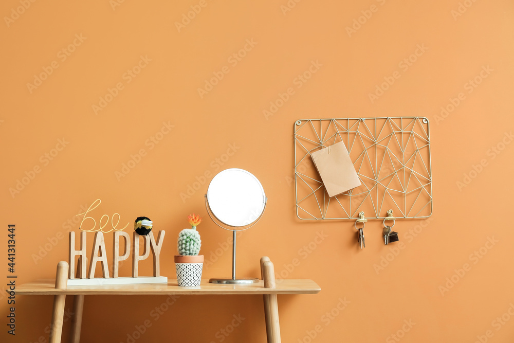 Table with decor and key holder hanging on color wall