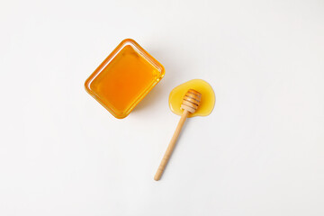 Wall Mural - Glass bowl with sweet honey and dipper on white background