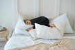 © Юлия Михайлова - a little girl is lying in bed in black home clothes and smiling