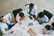 © Seventyfour - Top down view at group of doctors looking at X-ray images on display during medical council in conference room, copy space