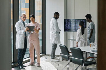 Wall Mural - Wide angle view at diverse group of doctors in conference room, copy space