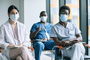 Wall Mural - Diverse group of doctors wearing masks while attending medical conference or seminar