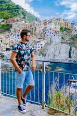 Wall Mural - Colors of Italy Manarola village, Cinque Terre park Italy during a summer day, vacation Italy colorful coast Manarola Cinque Terre Italy. Man watching the sunset