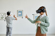 © Seventyfour - Minimal side view at cute girl wearing VR headset in art gallery while enjoying immersive experience, copy space