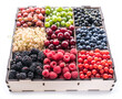 Colorful berries in wooden box on white background. Close-up.