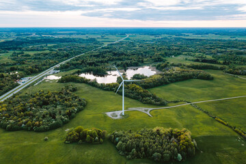aerial view of windmill turbine standing in green landscape in lithuania.