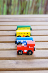 Sticker - Closeup of the colorful wooden small train wagon toys on the wooden surface