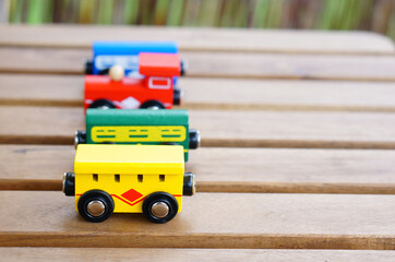 Sticker - Closeup of the colorful wooden small train wagon toys on the wooden surface