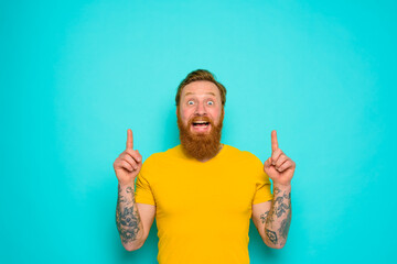 Wall Mural - Man with yellow t-shirt and beard is shocked about something