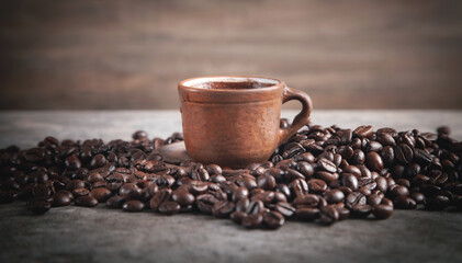  Clay cup of coffee on coffee beans.