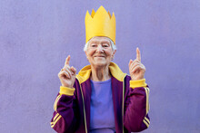 Smiling Elderly Sportswoman In Decorative Crown With Fingers Up