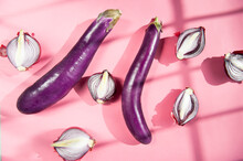 Eggplants And Onion On Pink Table