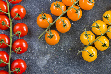 Wall Mural - Top view of red, yellow, and orange cherry tomatoes on a table