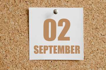 september 02. 02th day of the month, calendar date.White calendar sheet attached to brown cork board.Autumn month, day of the year concept