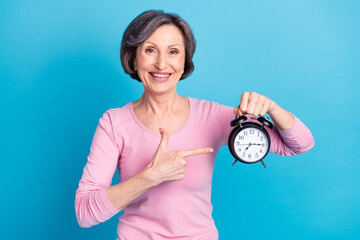Photo of happy cheerful smiling good mood woman point finger clock advertisement isolated on blue color background