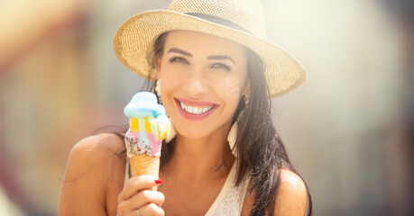 Wall Mural - Portrait of a beautiful young woman eating ice cream during a hot summer day