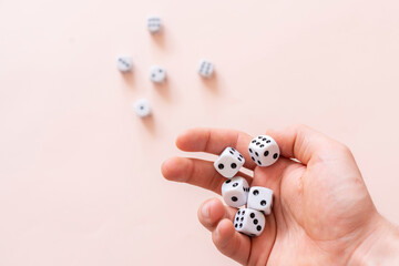 hands holding dice game cubes and roll on table. gamble chances