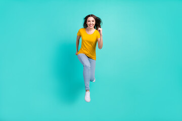 Poster - Full length photo of optimistic young lady run wear yellow t-shirt jeans isolated on teal color background