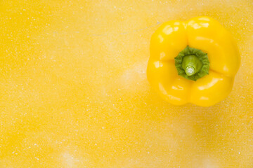 Wall Mural - Top view of a yellow bell pepper isolated on yellow background for a copy space