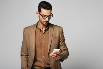 Poster - Arabian businessman using smartphone isolated on grey