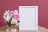 Fototapeta  - Empty white frame mock up with flowers on pink background. Temlate for your text or picture