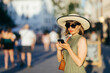 © AndyPhoton - Woman with phone and hat walking in the city